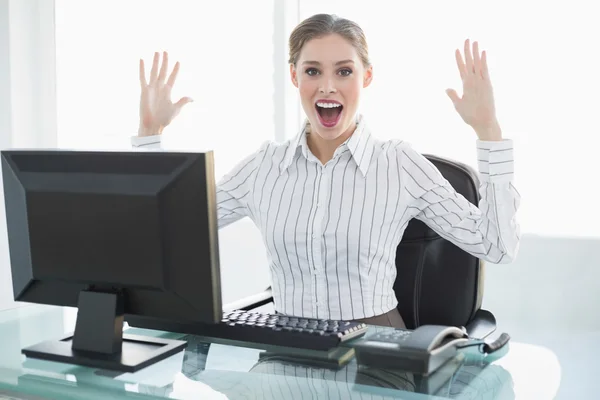 Cheering female businesswoman sitting at her desk — Stock Photo, Image