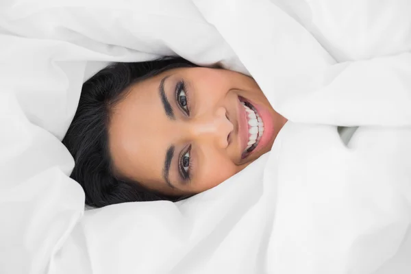 Content beautiful woman lying under cover on her bed — Stock Photo, Image