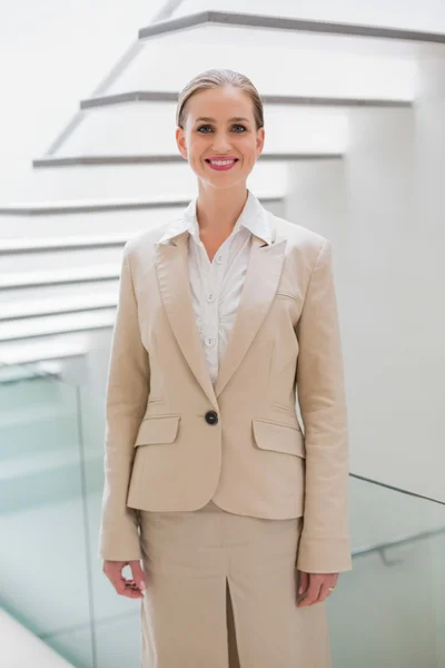 Lachende stijlvolle zakenvrouw permanent naast trap — Stockfoto