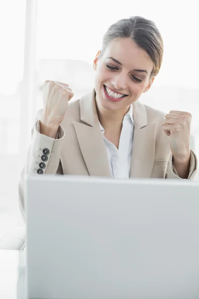 Joven empresaria contenta animando sentada en su escritorio —  Fotos de Stock