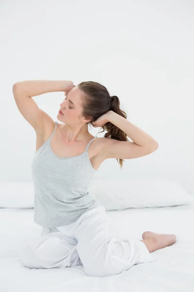 Mujer somnolienta estirando los brazos en la cama —  Fotos de Stock