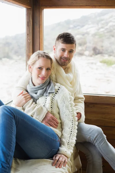 Couple en vêtements d'hiver assis contre la fenêtre — Photo