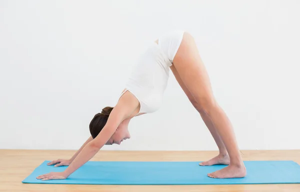 Vista lateral de una mujer haciendo ejercicio sobre una esterilla — Foto de Stock