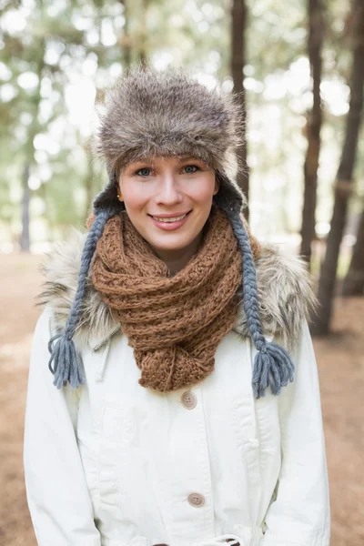 Kvinna som bär pälsmössa med ull halsduk och jacka i skogen — Stockfoto