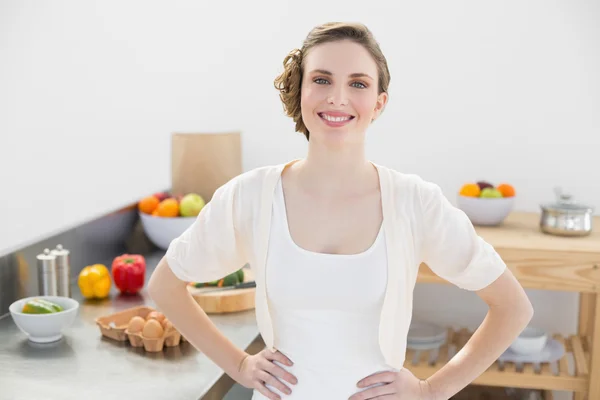 Allegro donna calma in posa in cucina con le mani sui fianchi — Foto Stock