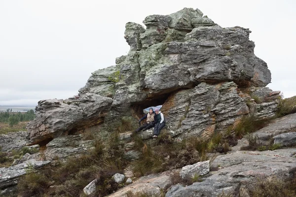 Casal jovem em rocha enorme enquanto em uma caminhada — Fotografia de Stock