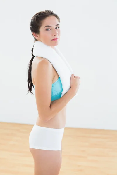 Fit žena s ručníkem kolem krku ve fitness studiu — Stock fotografie