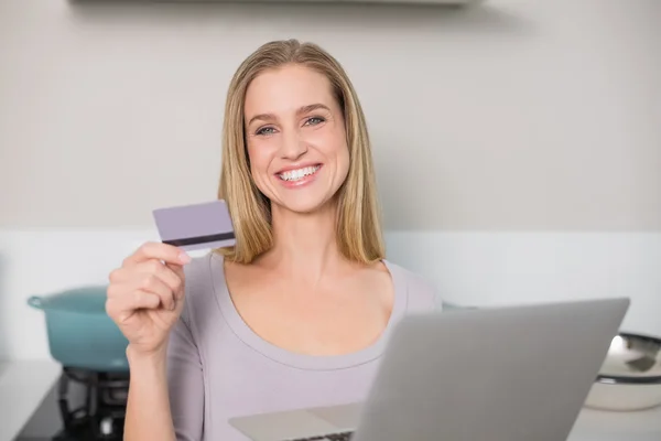 Modelo lindo feliz segurando laptop e cartão de crédito — Fotografia de Stock