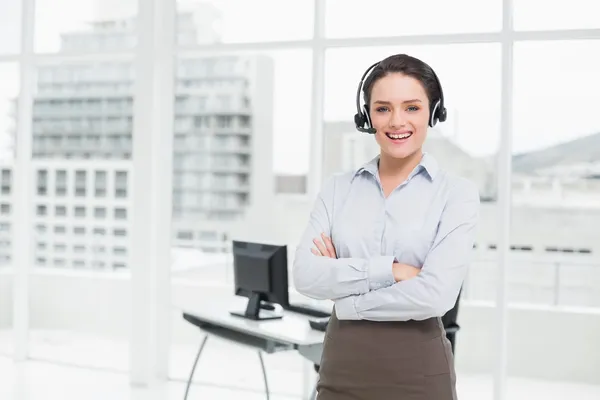 Elegante mujer de negocios sonriente con auriculares cruzados con los brazos —  Fotos de Stock