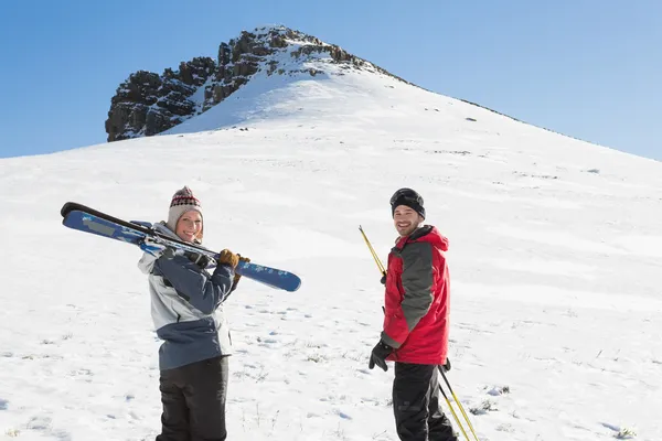 Rückseite Porträt eines lächelnden Paares mit Skistrecken im Schnee — Stockfoto