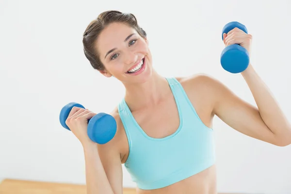 Mulher apta com halteres no estúdio de fitness — Fotografia de Stock