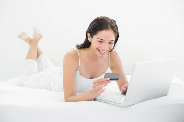 Mujer casual haciendo compras en línea en la cama —  Fotos de Stock