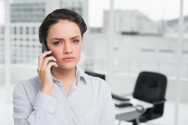 オフィスでの携帯電話を使用して深刻なエレガントな女性実業家 — ストック写真