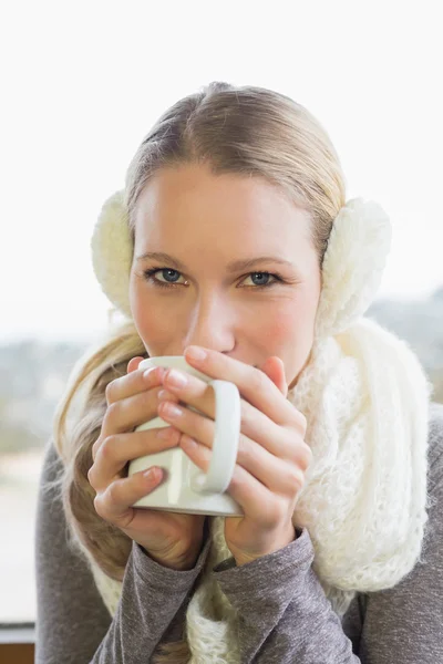 Žena nosí chránič ucha při pití kávy — Stock fotografie