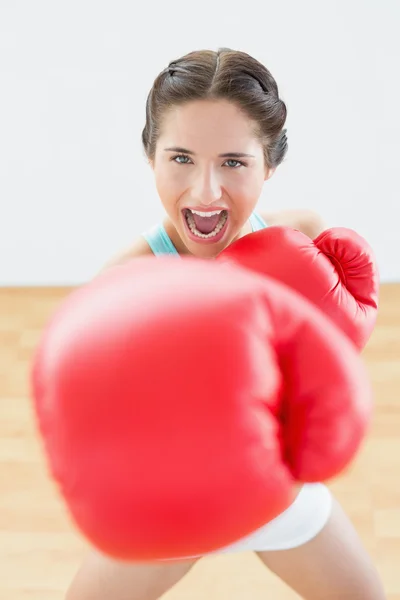 Beautiful young woman in red boxing gloves at fitness studio — Stock Photo, Image