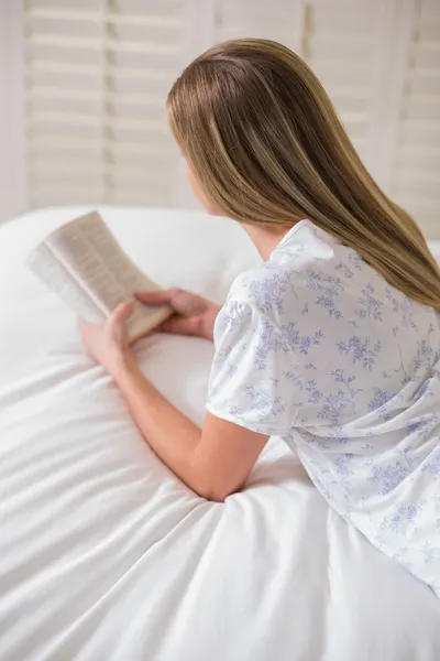 Natural woman lying on bed reading — Stock Photo, Image