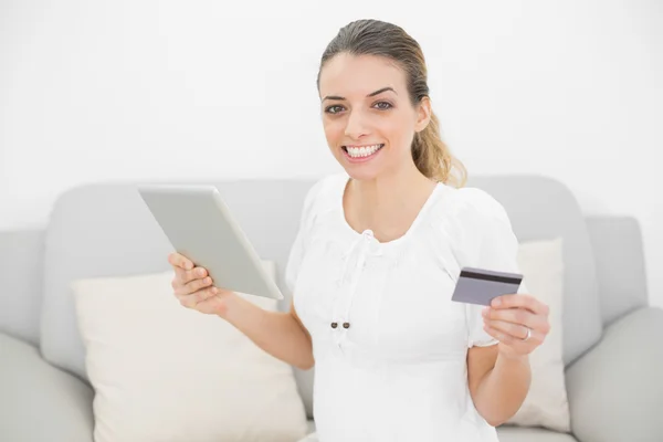 Mulher grávida atraente mostrando alegremente seu cartão de crédito — Fotografia de Stock