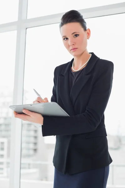 Elegant businesswoman writing notes in office — Stock Photo, Image