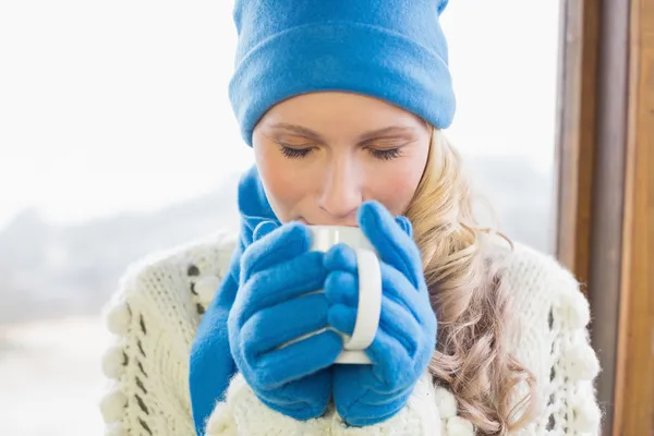 Cute woman drinking coffee in warm clothing — Stock Photo, Image