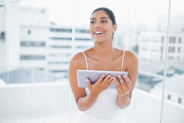 Laughing toned brunette holding tablet — Stock Photo, Image