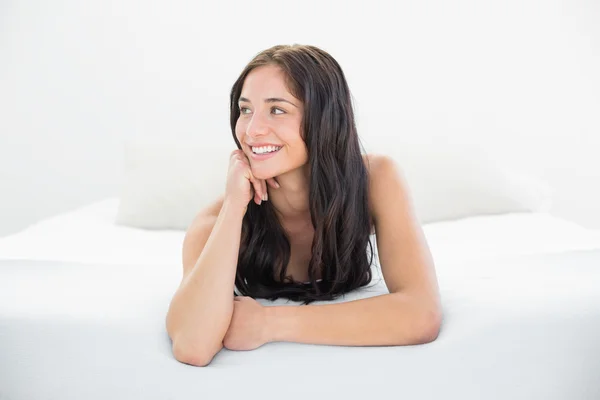 Happy woman looking away in bed — Stock Photo, Image