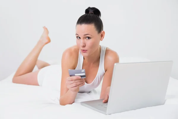 Portrait of a casual woman doing online shopping in bed — Stock Photo, Image