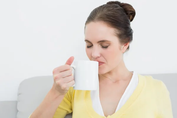 Ung kvinna dricker kaffe hemma — Stockfoto