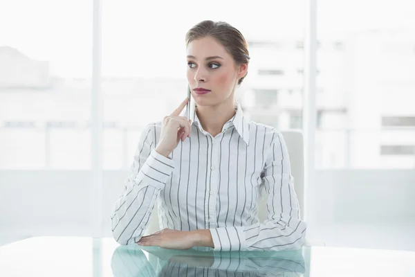 Ernsthafte junge Geschäftsfrau sitzt an ihrem Schreibtisch — Stockfoto