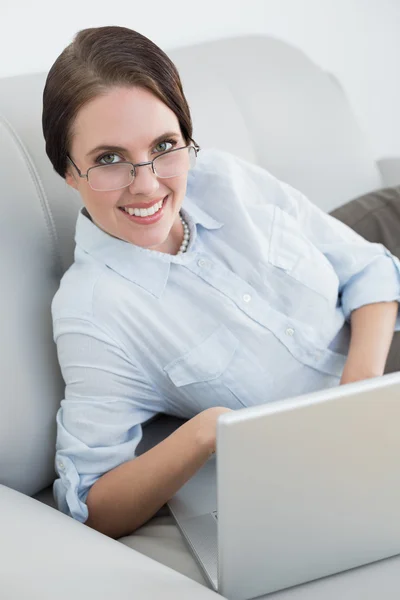 Porträt einer klug gekleideten Frau mit Laptop auf dem Sofa — Stockfoto