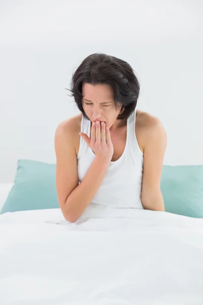 Jonge vrouw geeuwen in bed — Stockfoto