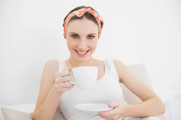 Frau lächelt in die Kamera und hält eine Tasse Tee — Stockfoto