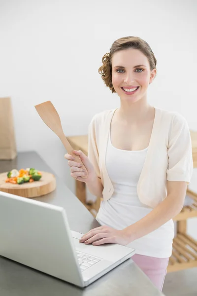Happy cute žena pomocí ji laptop stát v kuchyni — Stock fotografie