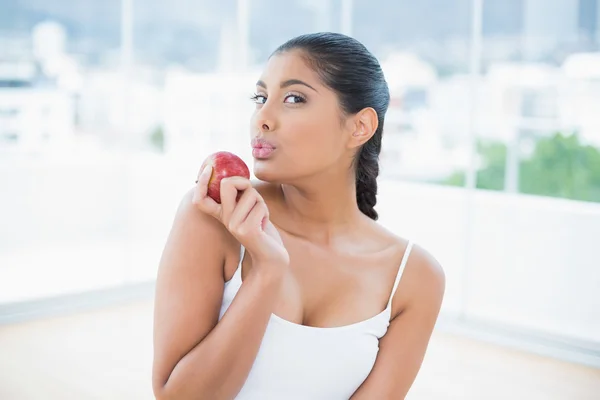 Calm toned brunette holding apple — Stock Photo, Image