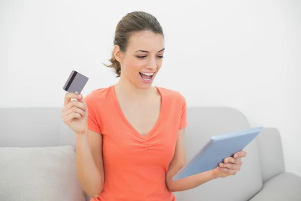 Allegro casual donna shopping a casa con il suo tablet — Foto Stock