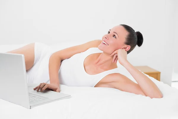 Dorywczo kobieta patrząc w górę podczas korzystania z laptopa — Zdjęcie stockowe