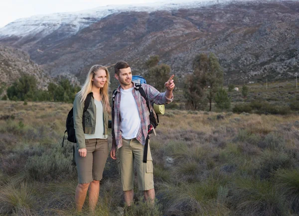 Fit young couple with backpacks on landscape — Stock Photo, Image