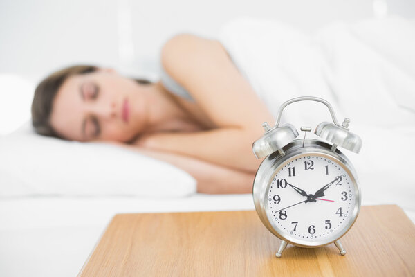 Мирная молодая женщина лежит под одеялом на кровати
