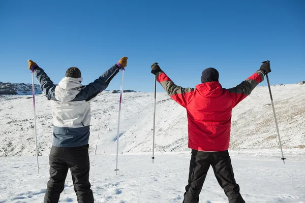 一对夫妇与滑雪杖在雪上的后视图 — 图库照片