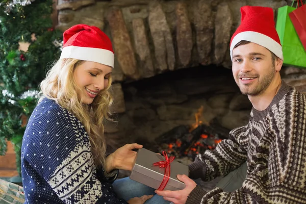 Hombre mujer regalando delante de la chimenea encendida durante la Navidad —  Fotos de Stock