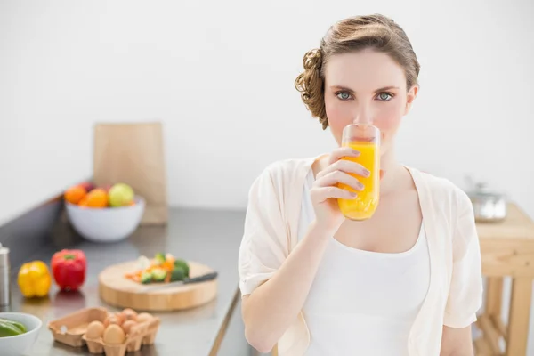 Linda mulher bebendo um copo de suco de laranja de pé — Fotografia de Stock