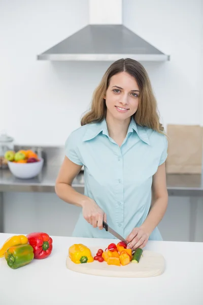 Carino giovane donna che taglia verdure in piedi in cucina — Foto Stock