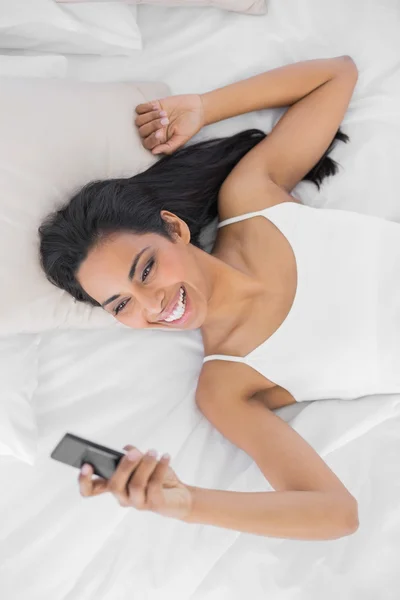 Donna sorridente naturale utilizzando il suo smartphone — Foto Stock