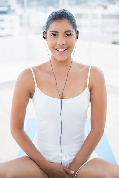 Brune tonique heureuse écoutant de la musique — Photo