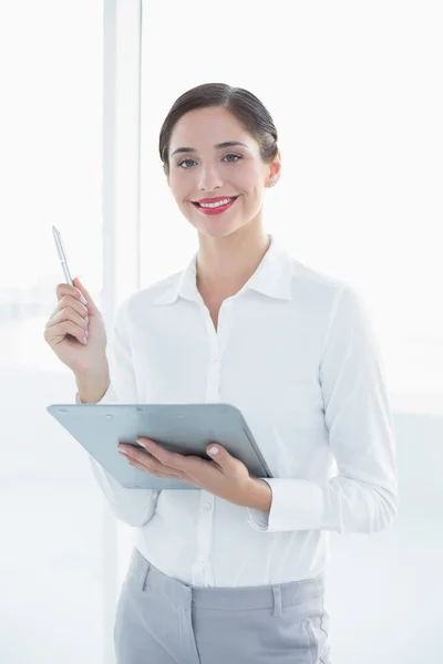 Business woman with clipboard and pen in office — Stock Photo, Image