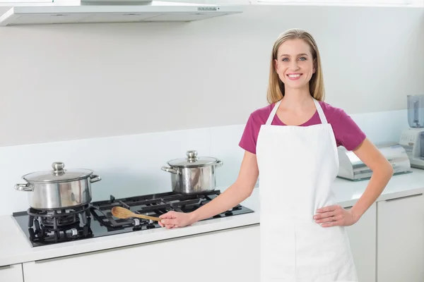 Casual happy blonde standing next to stove top — Stock Photo, Image