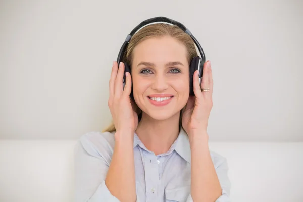 Lächelnde lässige Blondine beim Musikhören — Stockfoto