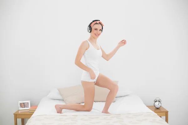 Bella donna che suona l'air guitar sul suo letto — Foto Stock