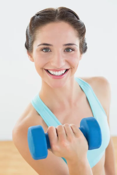 Vrouw met dumbbell op fitness-studio — Stockfoto