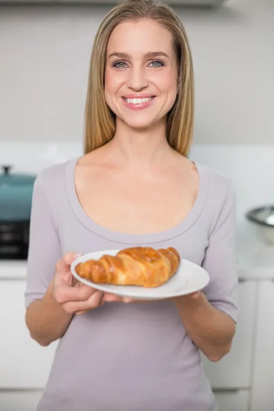 Modelo lindo alegre segurando placa com croissant — Fotografia de Stock