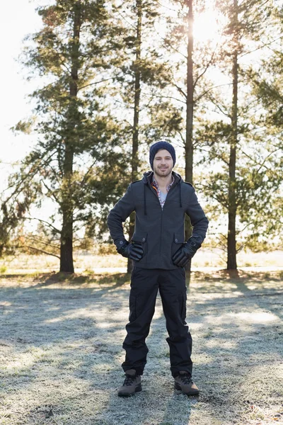 Uomo in abiti caldi fare una passeggiata nella foresta in una giornata invernale — Foto Stock